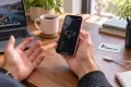 iPhone 13 mini ile düşük şarj seviyesini fark eden müşteri; Teknonand logolu masa