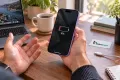 iPhone 17 ile düşük şarj seviyesini fark eden müşteri; Teknonand logolu masa