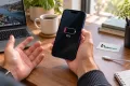 iPhone 17 Pro Max ile düşük şarj seviyesini fark eden müşteri; Teknonand logolu masa